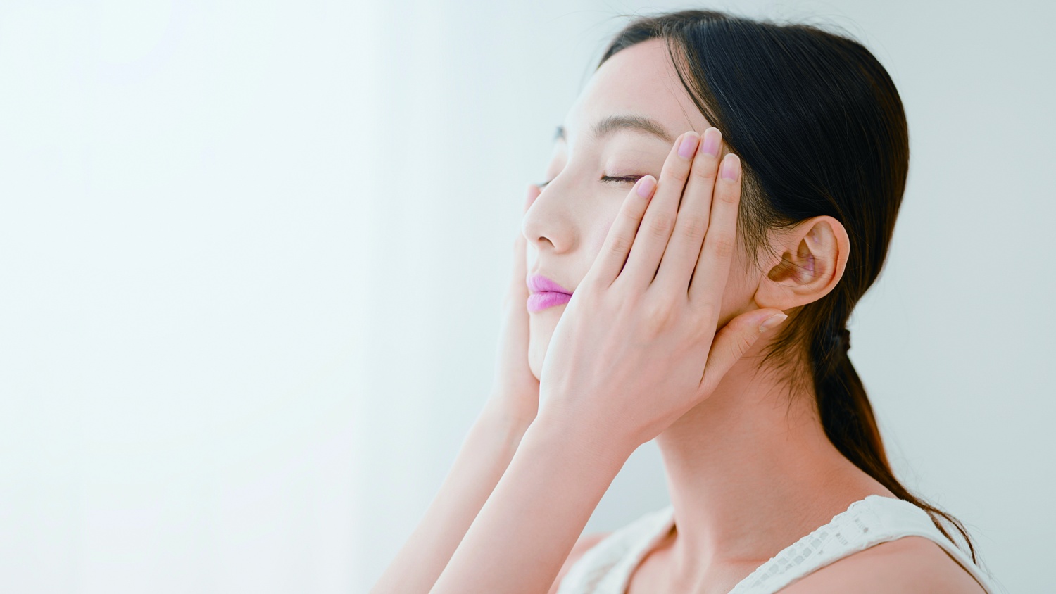 両手を頬に添えた女性
